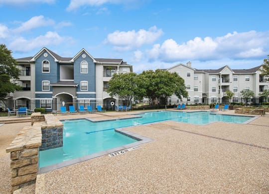 Community Swimming Pool with Pool Furniture at Hidden Creek Apartments located in Lewisville, TX.
