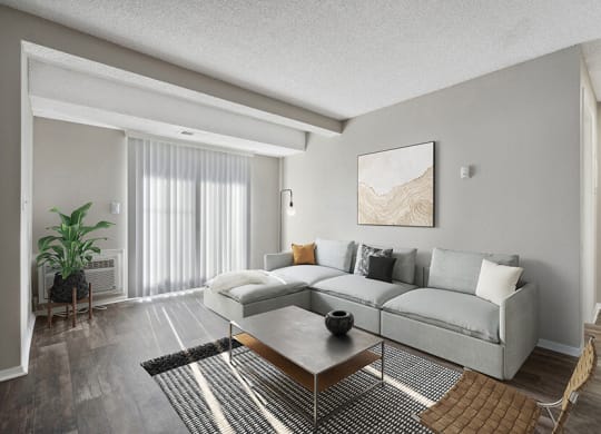 Model Living Room with Wood-Style Flooring and Patio Accessibility at Liberty Creek Apartments in Aurora, CO.