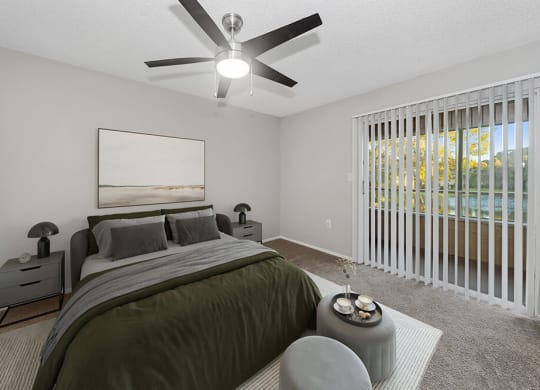 Model Bedroom with Carpet and Patio Accessibility at Walden Lake Apartments in Plant City, FL.