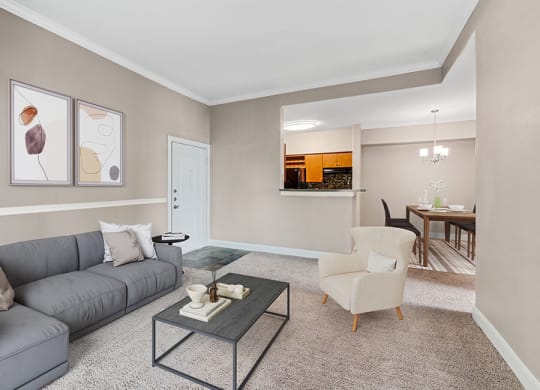 Model Living Room with Carpet and View of Kitchen/Dining Area at Park West Apartments located in Houston, TX.
