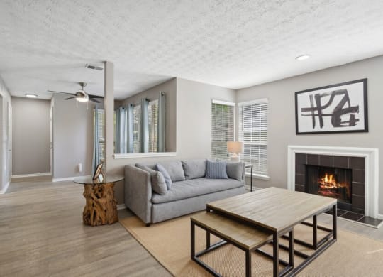Model Living Room with Fireplace and Wood-Style Flooring at Dunwoody Village Apartments in Atlanta, GA.