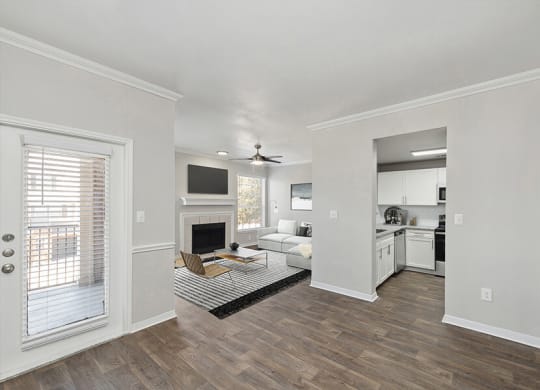 Model Living Room with Wood-Style Flooring and Fireplace at Chapel Hill Apartments in Lewisville, TX.