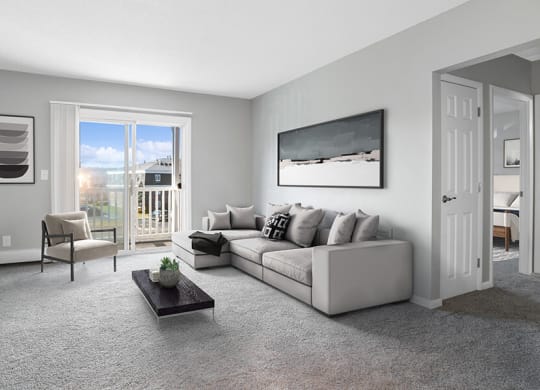 Model Living Room with Carpet and Patio Accessibility at Stone Ends Apartments in Stoughton, MA.