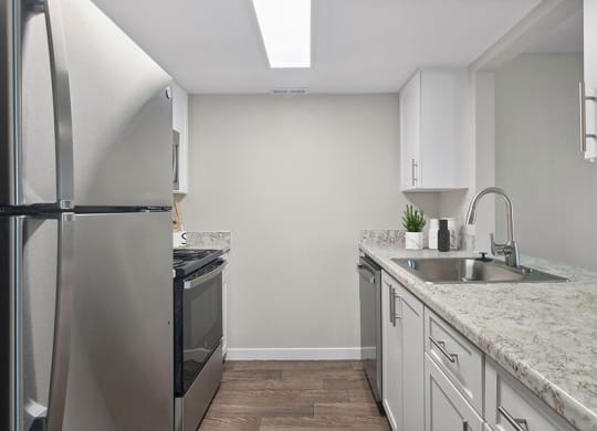 Model Kitchen with White Cabinets and Wood-Style Flooring at Overlook Point Apartments in Salt Lake City, UT.