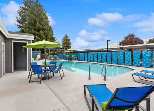 Community Swimming Pool with Pool Furniture at Meritage Apartments in Vallejo, CA.
