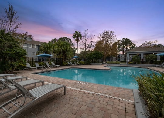 Community Swimming Pool with Pool Furniture at Westland Park Apartments in Jacksonville, FL.