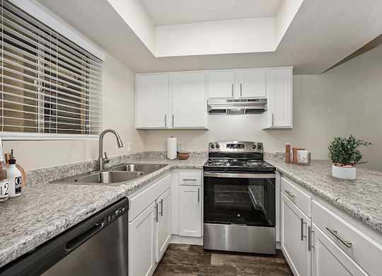 Model Kitchen with White Cabinets and Wood-Style Flooring at Butler Ridge Apartments located in Glendale, AZ.