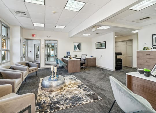 Leasing office interior with couches and chairs and a coffee table in the middle of the room