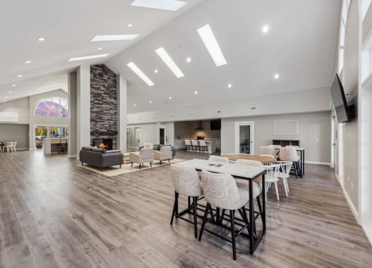 a large living room with a table and chairs and a fireplace