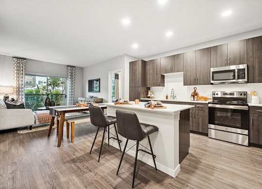 Model Kitchen with Dark Wood Cabinets and Wood-Style Flooring at Glen 91 Apartments located in Glendale, AZ.