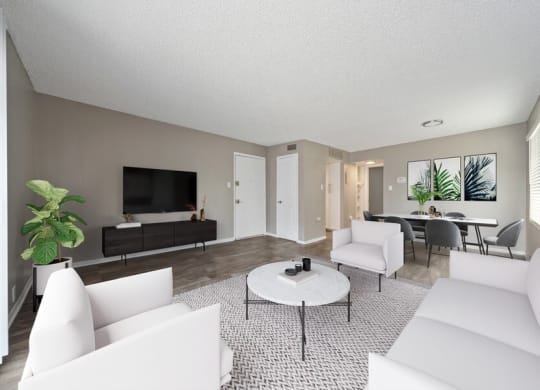 South Denver, CO, Pet-Friendly Affordable Apartments - Bridges at 9 Mile Station - A Living Room With White Seating, Round Coffee Table, And Wall-Mounted Television.