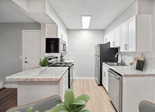 Model Kitchen with White Cabinets and Wood-Style Flooring at Waterfront Apartments in Lakewood, CO.