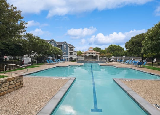 Community Swimming Pool with Pool Furniture at Hidden Creek Apartments located in Lewisville, TX.