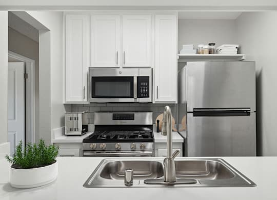 Model Kitchen with White Cabinets and Wood-Style Flooring at Fullerton Hills Apartments located in Fullerton, CA.