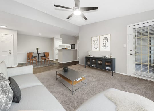 Model Living Room with Carpet, Patio Accessibility and View of Kitchen/Dining Area at Walden Lake Apartments in Plant City, FL.