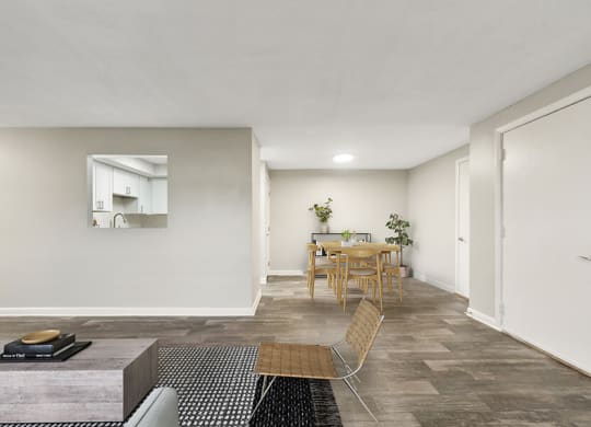 Model Living Room with Wood-Style Flooring and View of Dining Room at Meadows at Marlborough Apartments located in Marlborough, MA.
