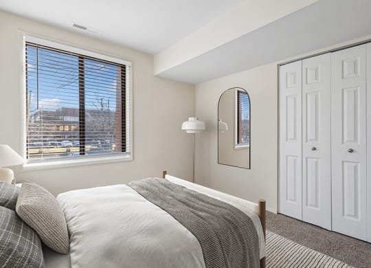 Model Bedroom with Carpet and Window View at Spring Parc Apartments in Silver Spring, MD.