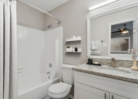 a bathroom with a shower and a sink and a toilet
