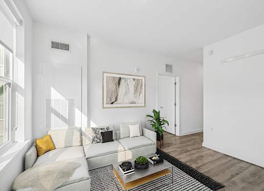 Model Living Room with Wood-Style Flooring and Window View at Stella Apartments located in New Carrollton, MD.
