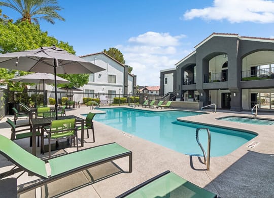 Community Swimming Pool with Pool Furniture at Meadow Ridge Apartments located in Las Vegas, NV.