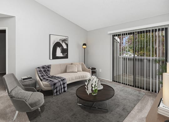 Model Living Room with Carpet and Patio Accessibility at The Meritage Apartments in Vallejo, CA.
