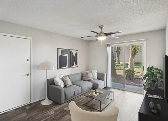 Model Living Room with Wood-Style Flooring and Patio Accessibility at Solano Springs Apartments located in Tucson, AZ.