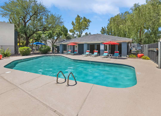 Community Swimming Pool with Pool Furniture at Solano Springs Apartments in Tucson, AZ.