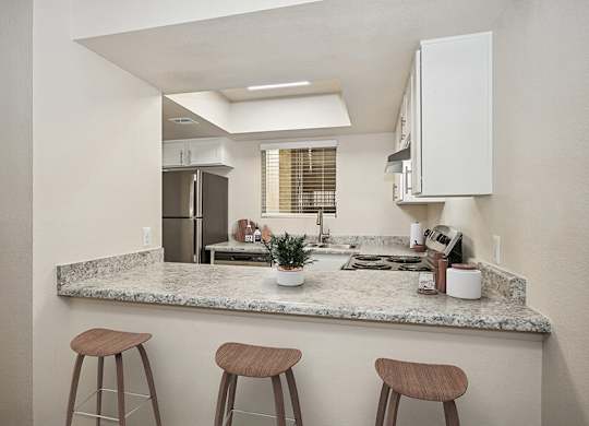 Model Kitchen with White Cabinets and Wood-Style Flooring at Butler Ridge Apartments located in Glendale, AZ.