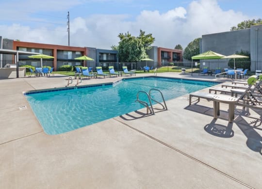 Community Swimming Pool with Pool Furniture at Indigo Park Apartments in Albuquerque, NM.
