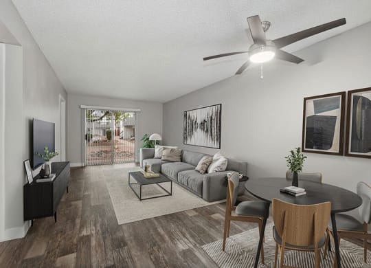 Model Living Room with Wood-Style Flooring and Patio Accessibility at Crystal Creek Apartments located in Phoenix, AZ.