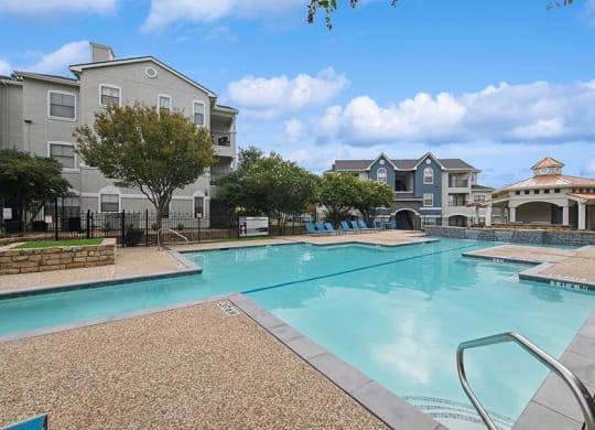Community Swimming Pool with Pool Furniture at Hidden Creek Apartments located in Lewisville, TX.
