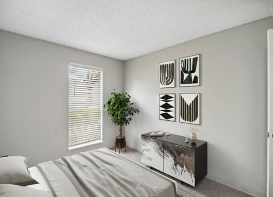 a bedroom with a bed and a dresser in front of a window