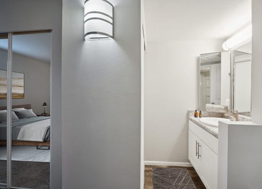 Model Bathroom with White Cabinets and Wood-Style Flooring at Country Club Verandas Apartments located in Mesa, AZ.