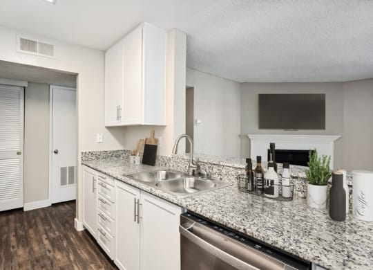 Model kitchen with granite-style counters and white cabinets