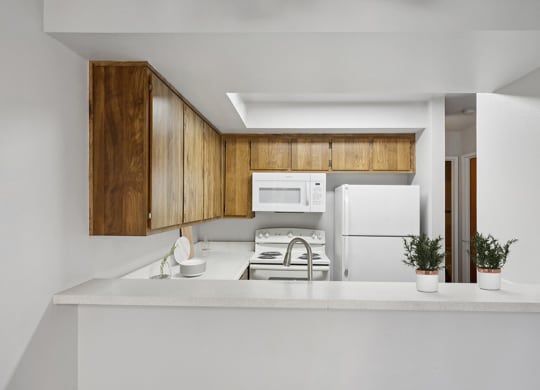 Model Kitchen with Dark Wood Cabinets and Wood-Style Flooring at Creek at 2645 Apartments located in Sacramento, CA.