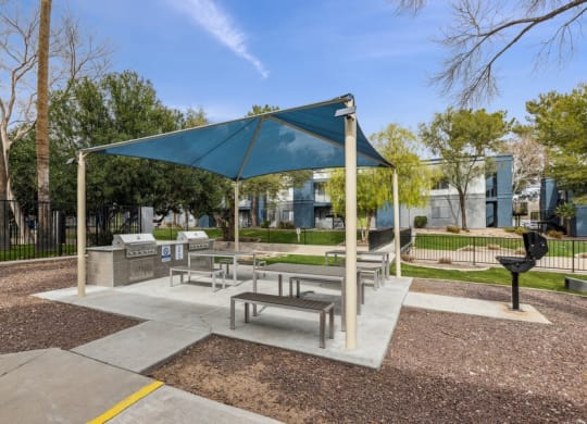 a picnic area with benches and a grill at the preserve at great pond apartments in windsor