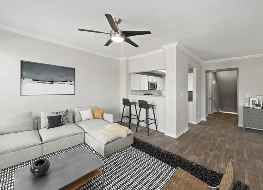 Model Living Room with Wood-Style Flooring and View of Kitchen at Chapel Hill Apartments in Lewisville, TX.