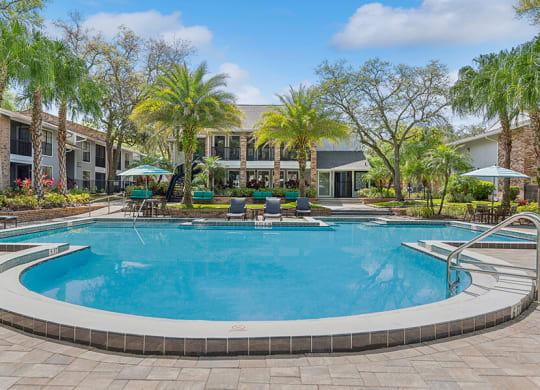 Community Swimming Pool with Pool Furniture at Grand Pavilion Apartments in Tampa, FL.