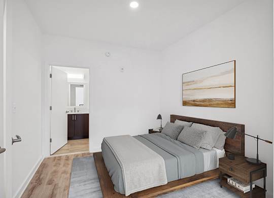 Model Bedroom with Wood-Style Flooring and attached Bathroom at Stella Apartments located in New Carrollton, MD.