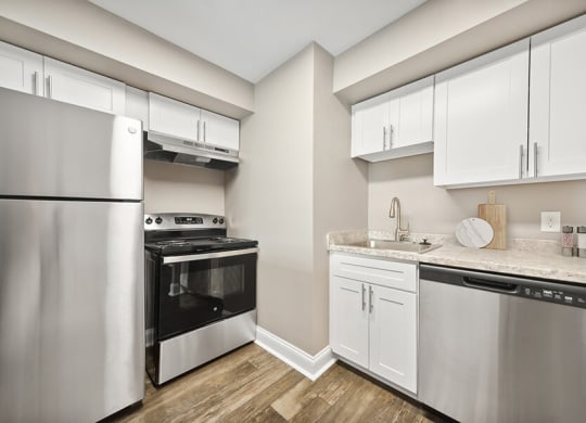 Model Kitchen with White Cabinets and Wood-Style Flooring at Heights at Marlborough Apartments located in Marlborough, MA.