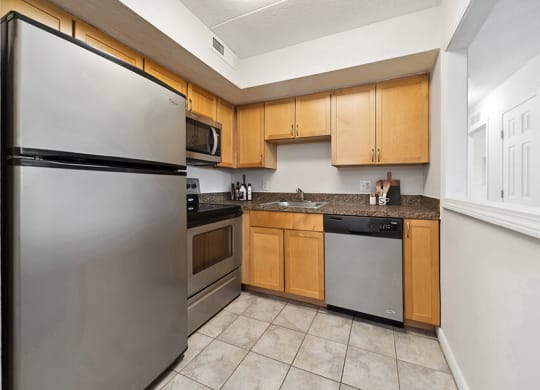 Model Kitchen with Tile Flooring and Oak Cabinets at Heights Marlborough Apartments in Boston, MA.