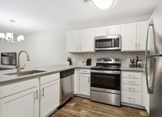 Model kitchen with white cabinetry at Retreat at Stonecrest Apartments