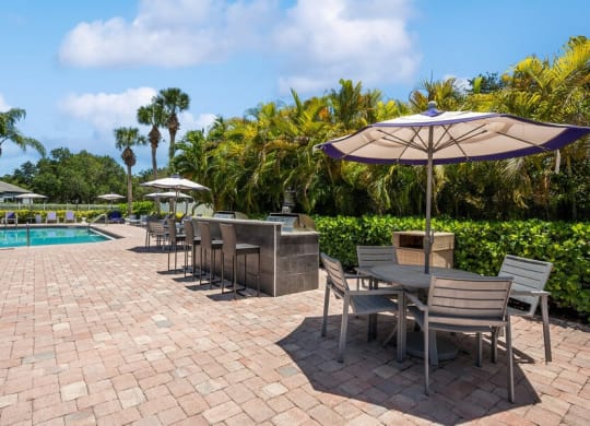 Outdoor BBQ Area with Furniture at Waverley Place Apartments in Naples, FL.