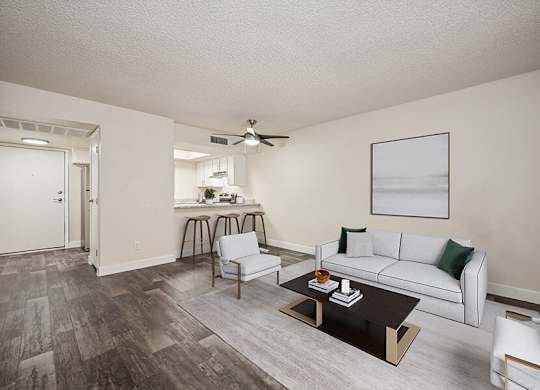 Model Living Room with Wood-Style Flooring and view of Kitchen at Butler Ridge Apartments located in Glendale, AZ.