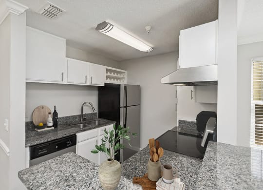 Model Kitchen with White Cabinets and Wood-Style Flooring at Shadow Ridge Apartments in Riverdale, GA.