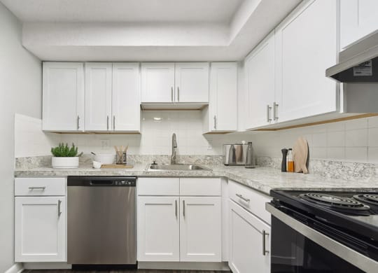 Model Kitchen with White Cabinets and Wood-Style Flooring at Meadows at Marlborough Apartments located in Marlborough, MA.
