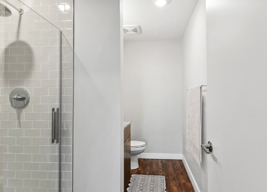 Model Bathroom with Wood-Style Flooring, Dark Oak Cabinets & Shower/Tub at Seven Skies Apartments located in Sandy, UT.