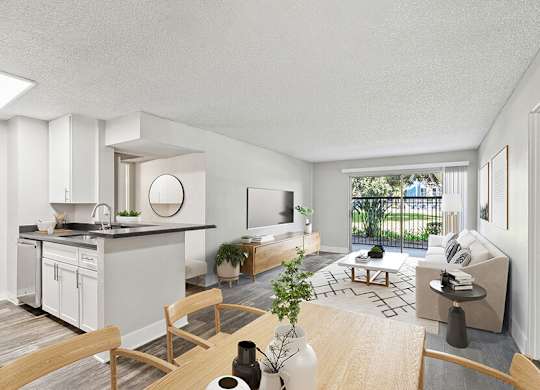 Model Dining Room with Wood-Style Flooring and View of Living Room with Patio Accessibility at Madison Park Apartments located in Anaheim, CA.