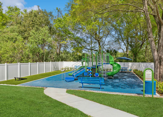 Community Playground with Slide and Corn Hole Area at Grand Pavilion Apartments in Tampa, FL.