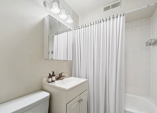Model Bathroom with White Cabinets and Shower/Tub at Heights Marlborough Apartments in Boston, MA.